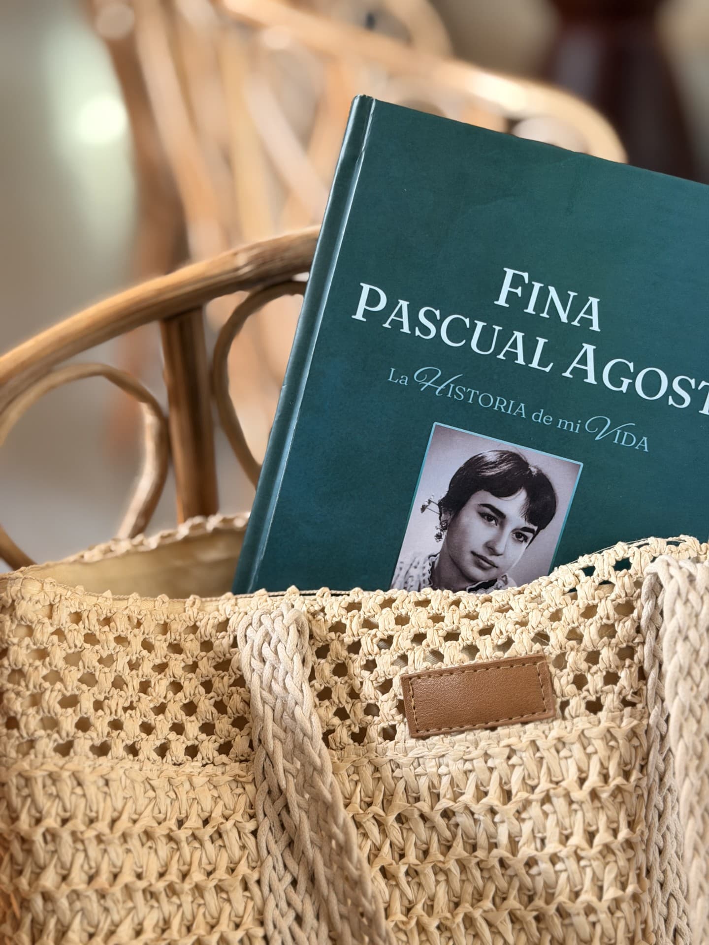 Portada personalizada con nombre y fotografía, asomando de un bolso de rafia